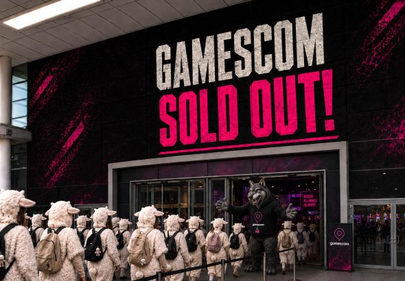 Gamescom entrance in Cologne with the slogan "Gamescom Sold Out", showing a line of sheep being let inside by a wolf.